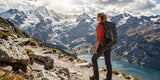 A female hiker wearing women's travel pants in the panoramic Swiss Alps landscape