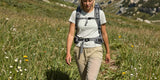 Woman hiking in beige pants through a mountain meadow