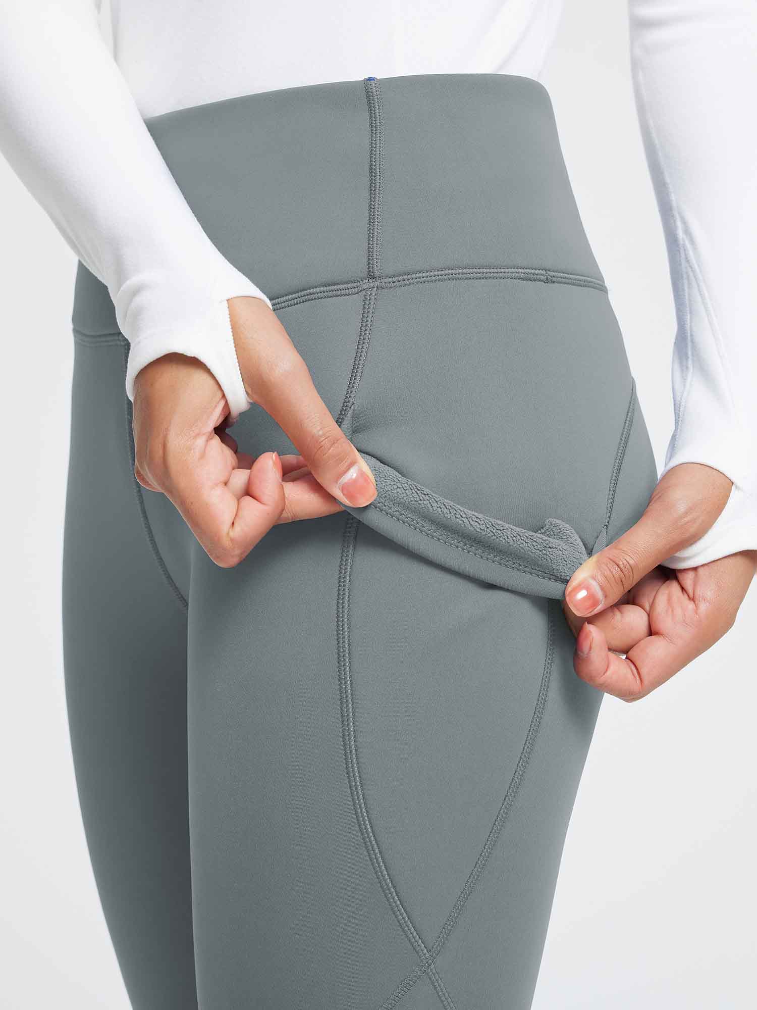 Gray thermal fleece-lined yoga leggings with high waist and deep pockets, showing inner warmth. #color_Dark Gray