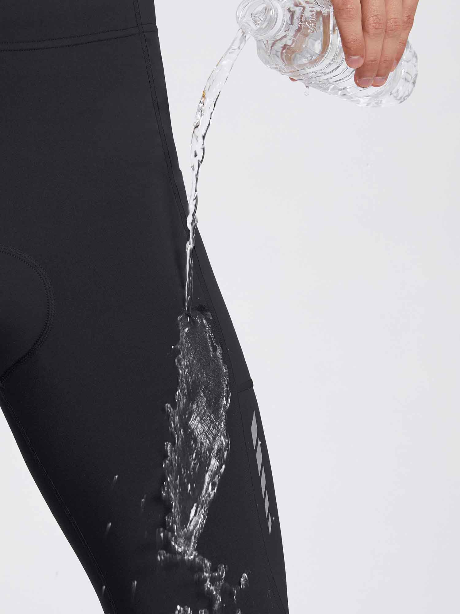 Black men's thermal cycling tights with water beading off the fabric, showing water-resistant feature. #color_Black