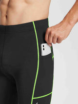 Black men's thermal cycling tights with neon green stitching and a side pocket holding a smartphone. #color_Flourescent Green