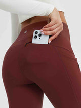 Close-up of wine red fleece-lined yoga leggings showing a phone being placed in a side pocket. #color_Wine Red