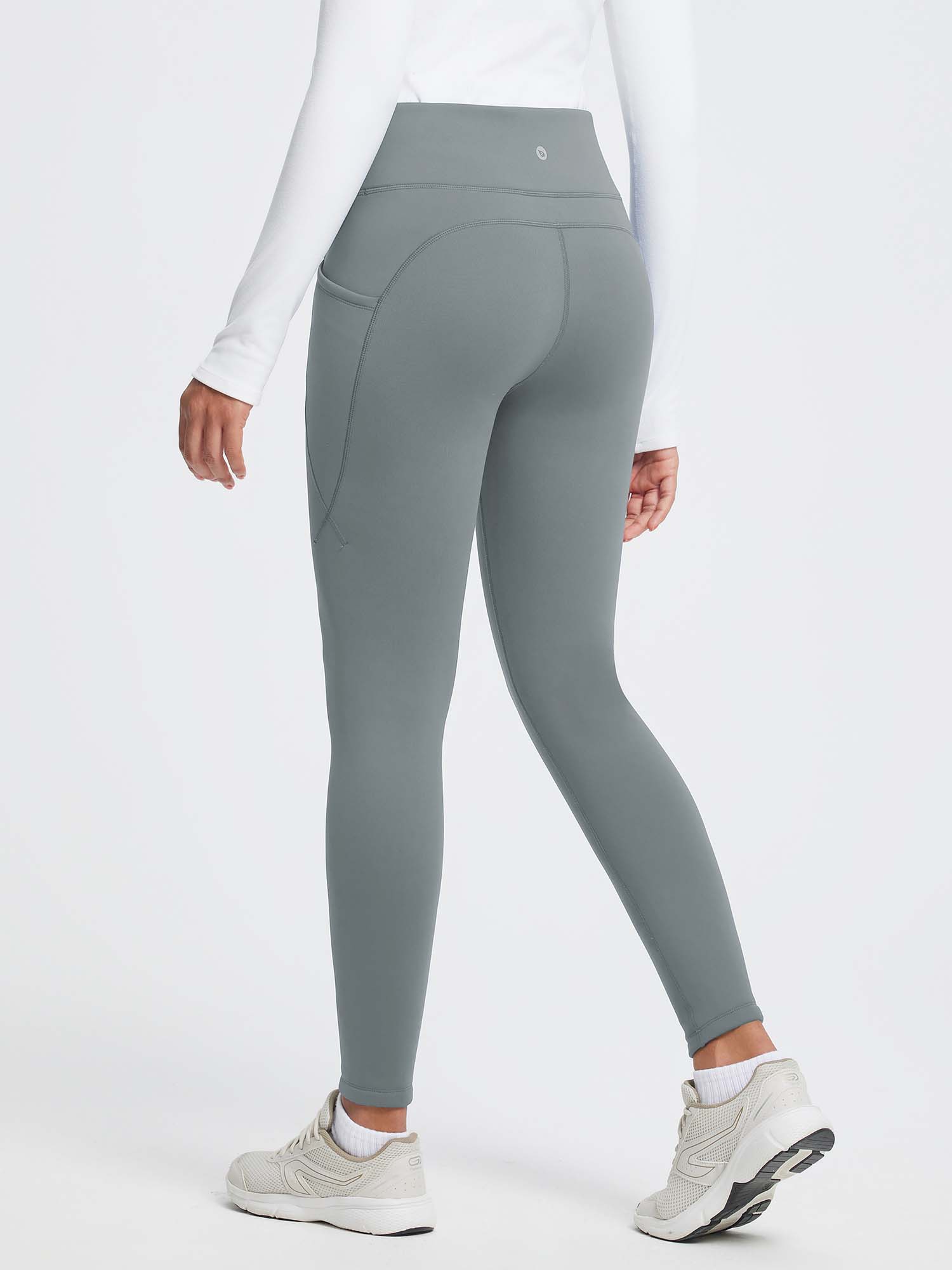 Gray 27" thermal fleece high-waist yoga leggings with pockets, worn by a woman in a white long-sleeve shirt. #color_Dark Gray