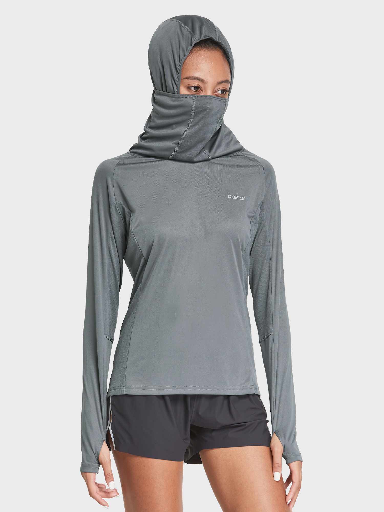 Woman in gray UPF 50+ hiking shirt with hood/face cover and black shorts.