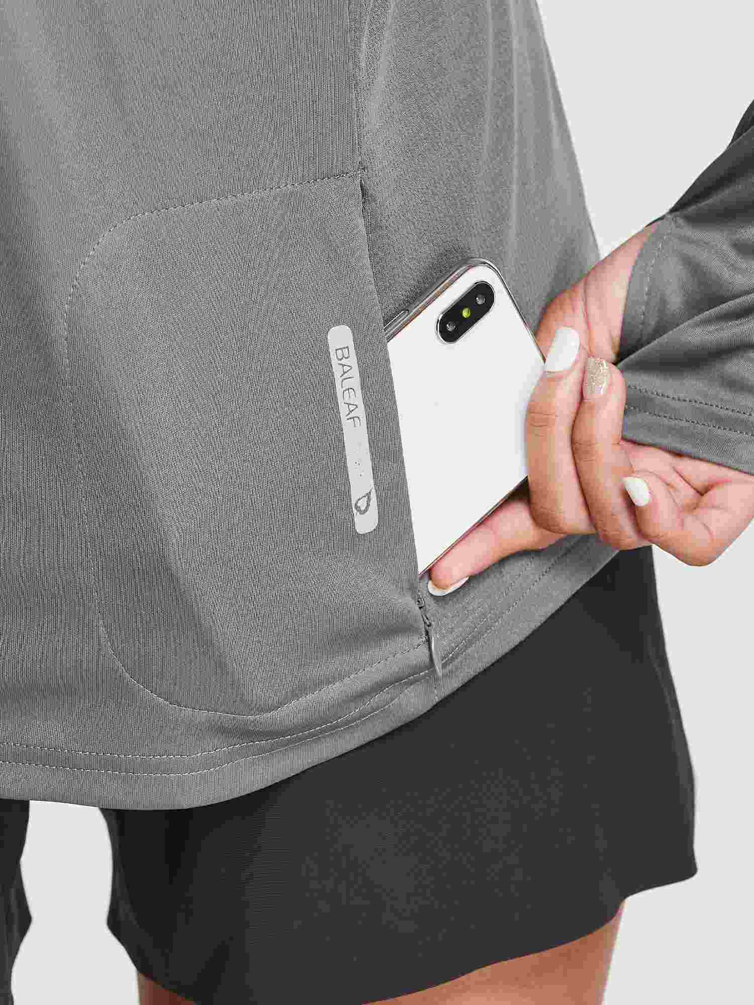 Women's gray UPF 50+ hiking shirt with a phone placed in the zippered pocket, showing the Baleaf logo. #color_Dark Gray