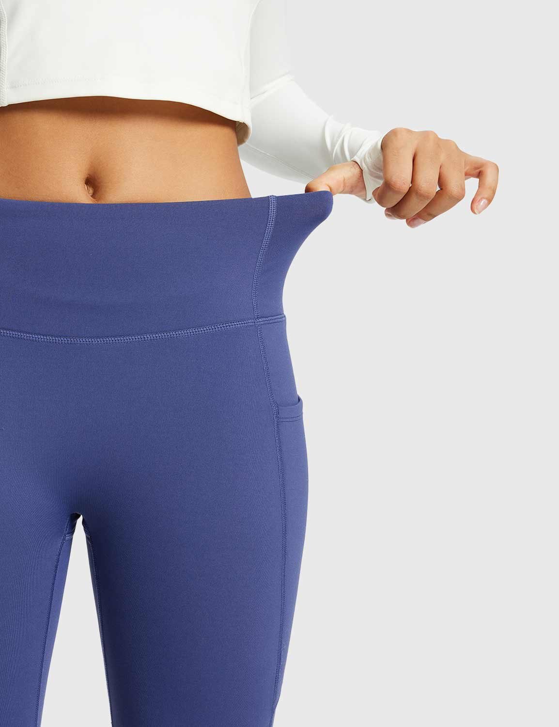 Navy blue thermal warm flare pants with high waist and side pocket, showing stretch. #color_Navy Blue