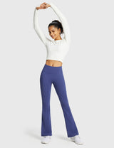 Woman in white long-sleeve crop top and blue thermal warm flare pants stretching. #color_Navy Blue