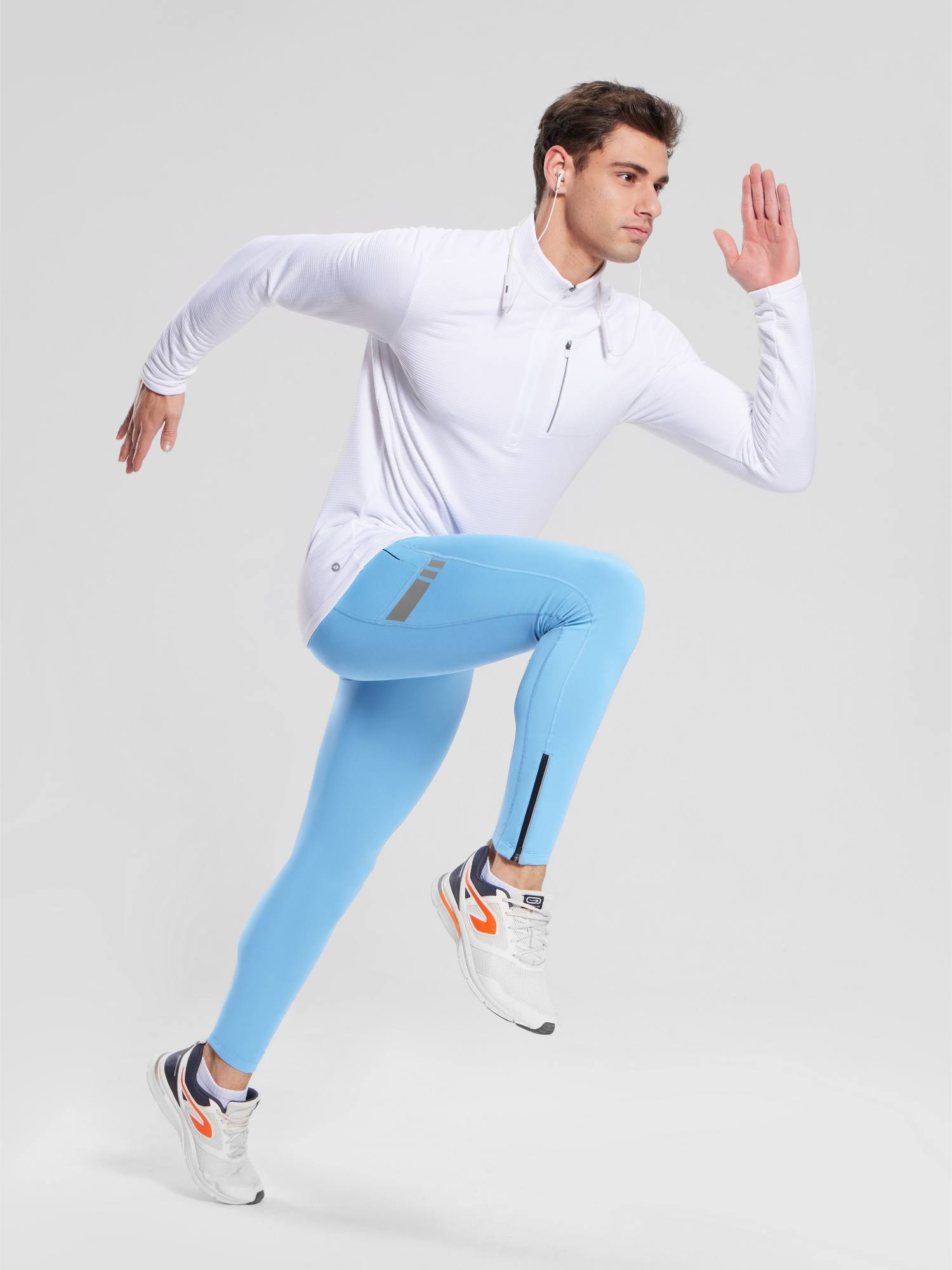 Men's light blue fleece-lined cycling tights with ankle zippers and reflective detail. Paired with white athletic top.