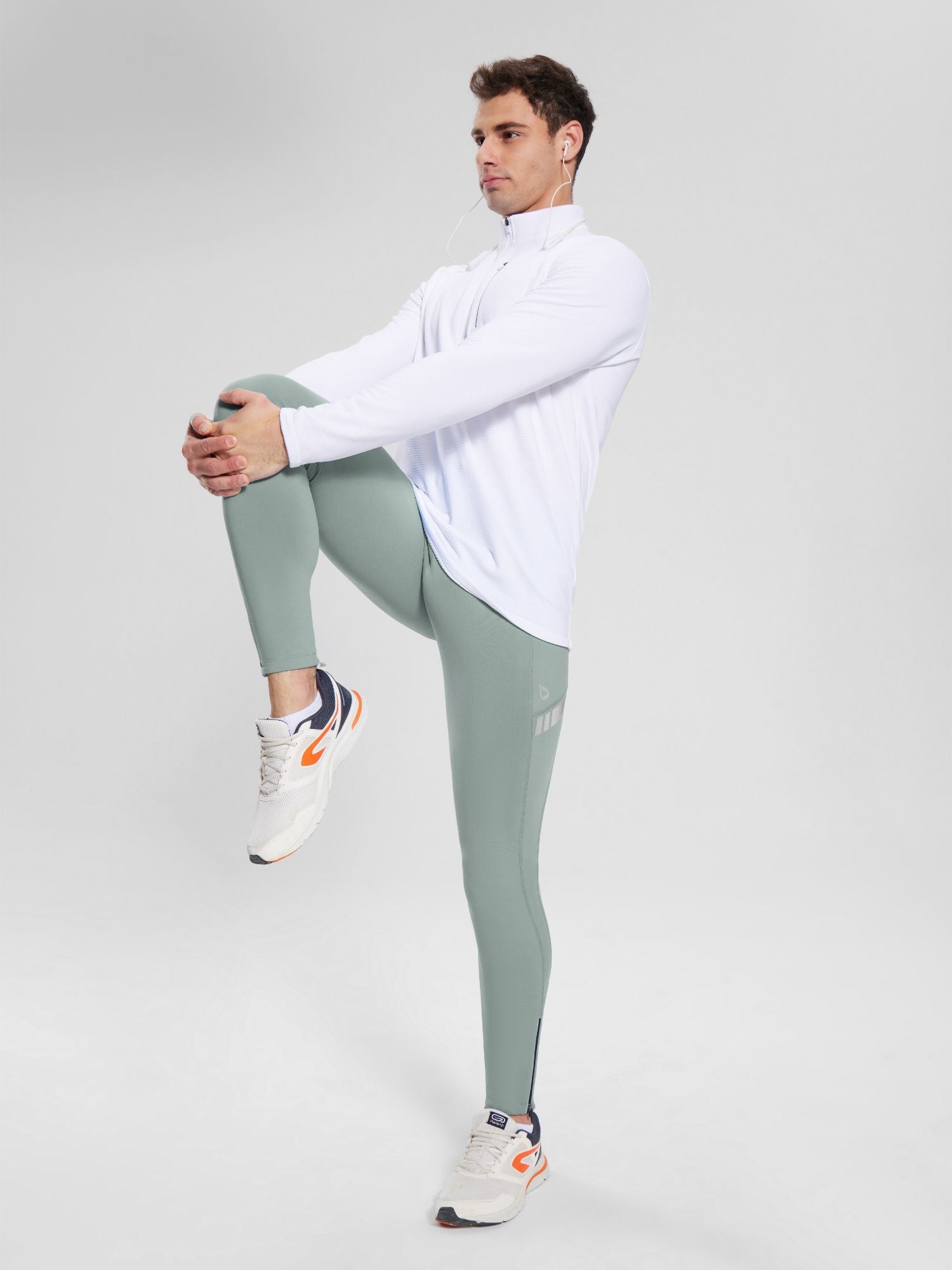 Men's 30" fleece-lined cycling tights in light green with reflective details, shown on a model stretching. #color_Gray