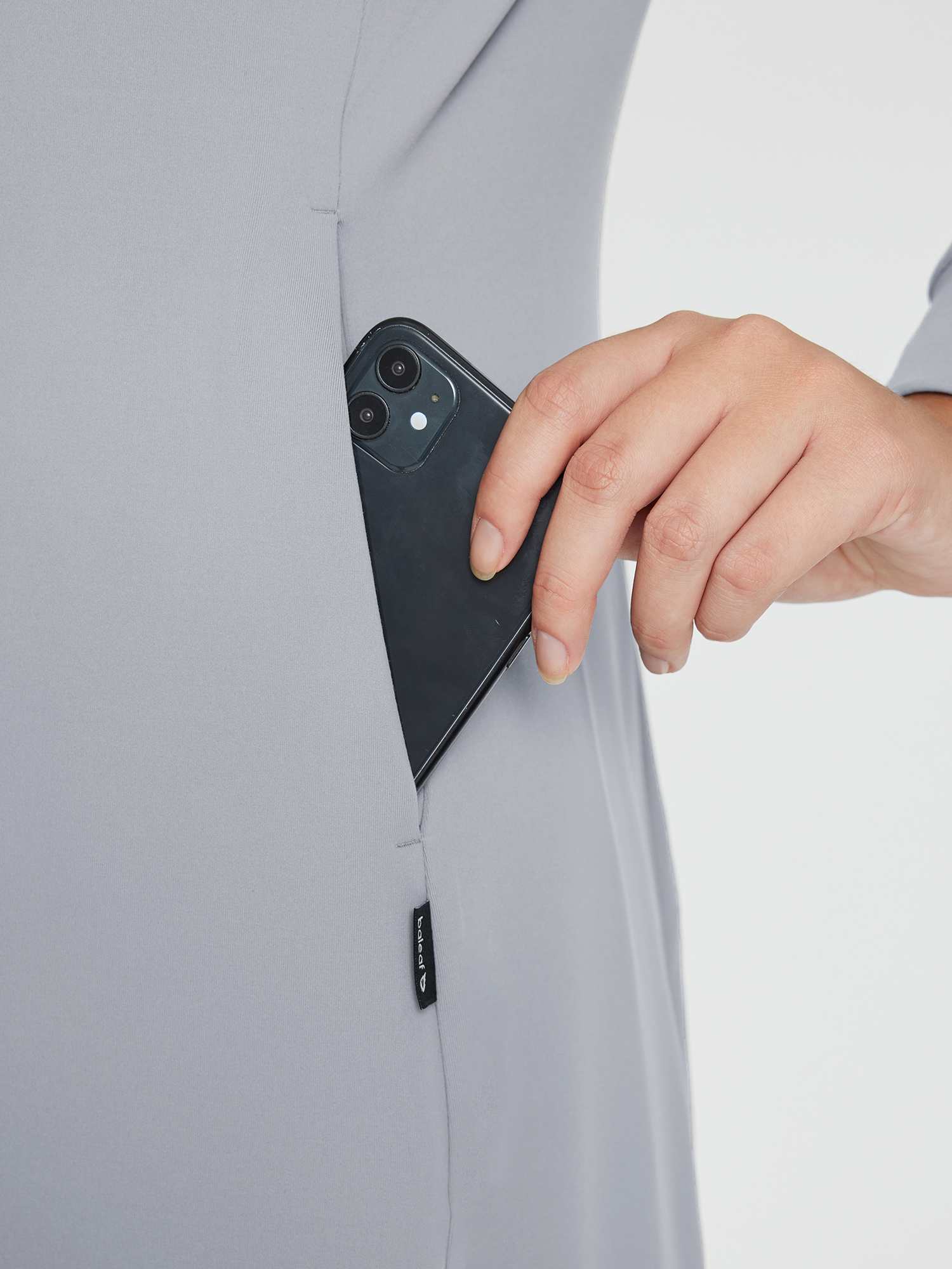 Fleece-lined knit dress in gray with a side pocket holding a smartphone. Features a discreet Baleaf logo tag. #color_Gray