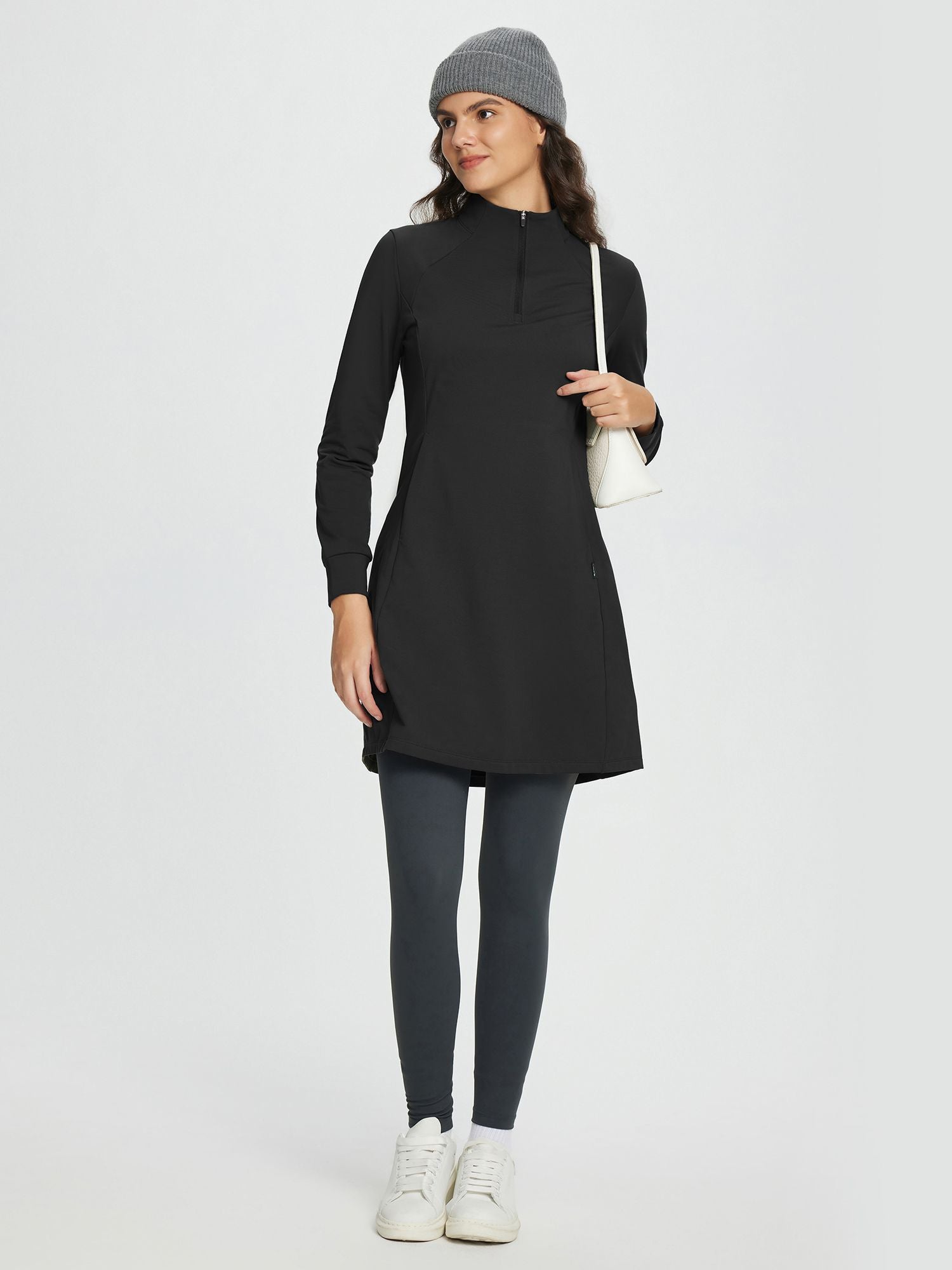Black fleece-lined knit dress, mock neck, half-zip, side pockets. Paired with grey leggings. #OutdoorDress #FleeceLined