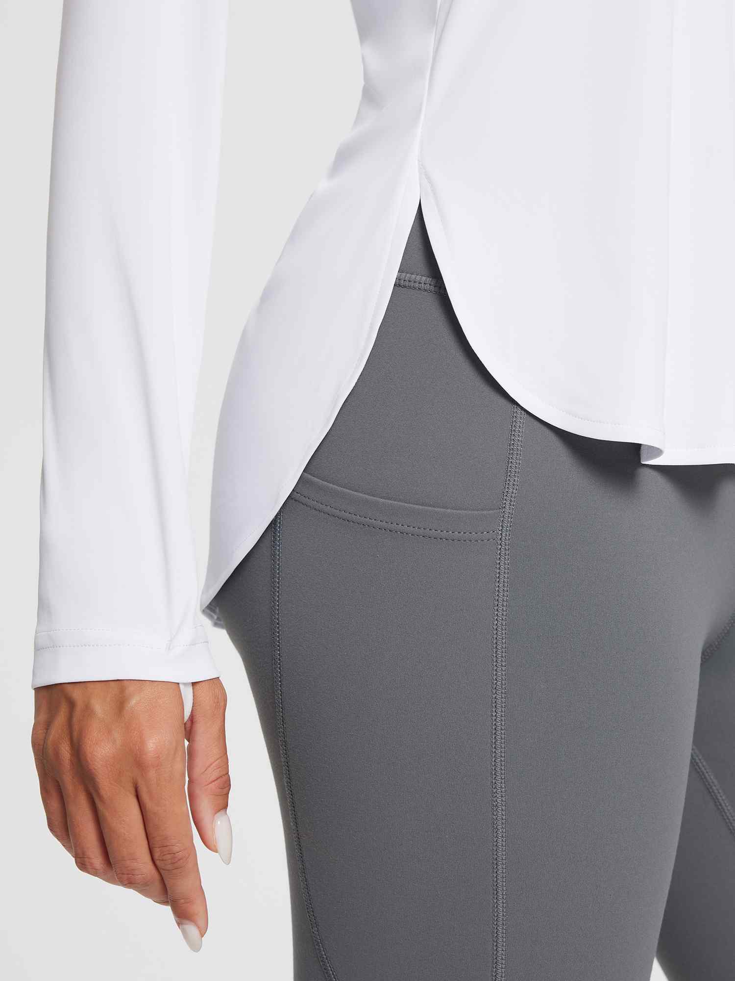 White outdoor long-sleeve t-shirt with side slits and grey leggings, UPF 50+.