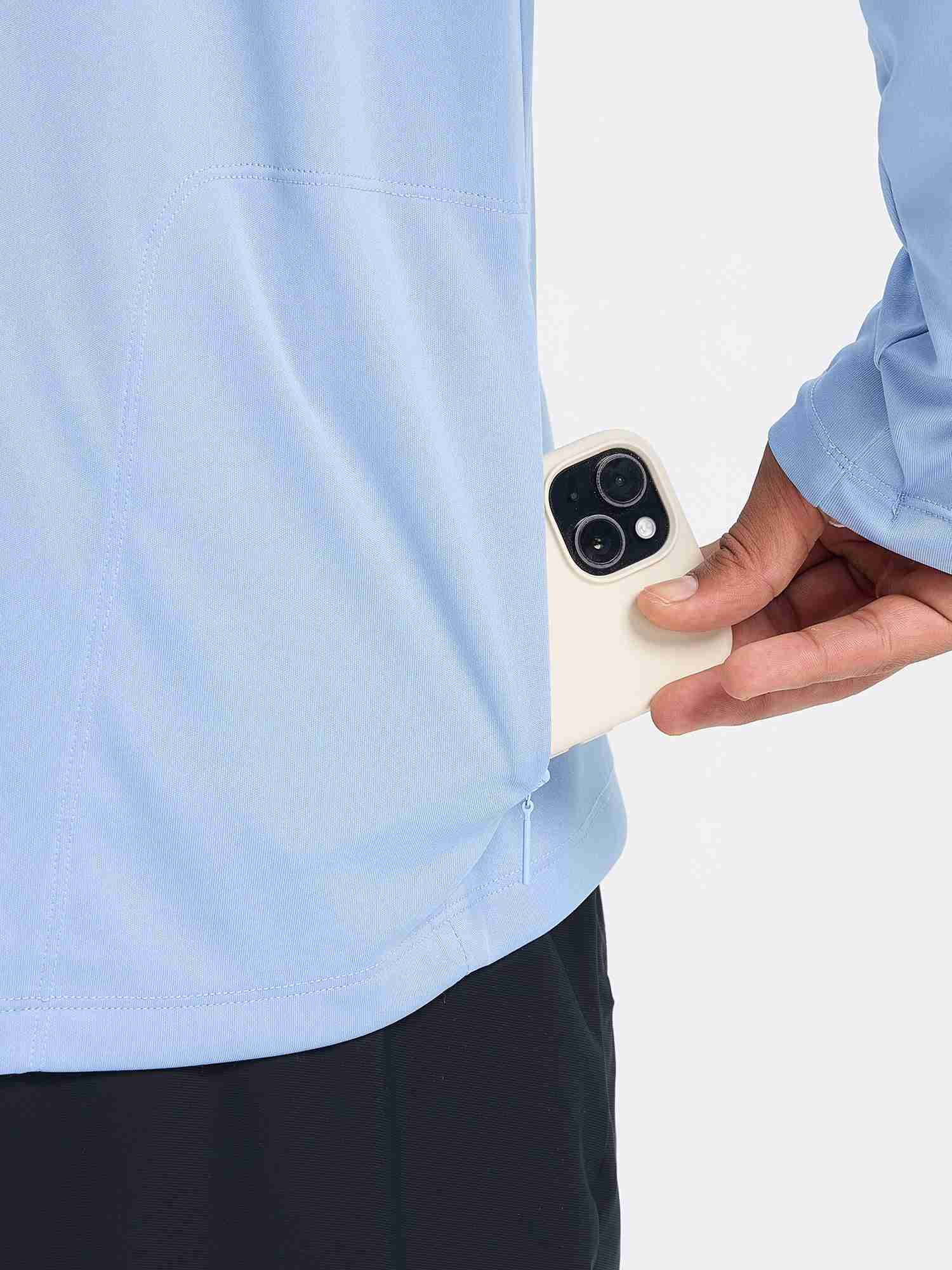 Man placing smartphone into hidden zippered pocket on light blue long sleeve cycling shirt. #color_Light Blue
