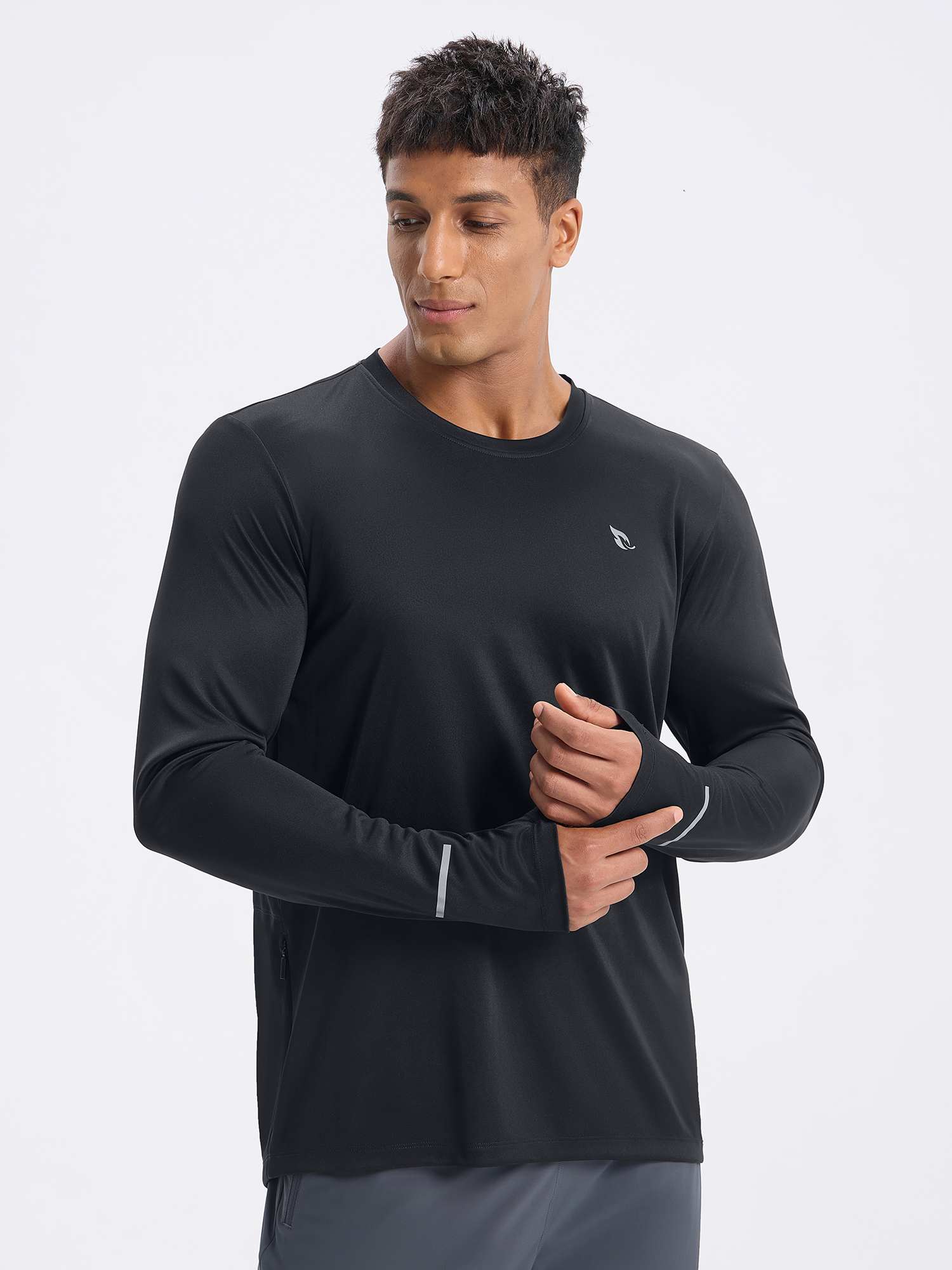 Man wearing a black long sleeve cycling shirt with thumbholes and reflective details. #color_Black