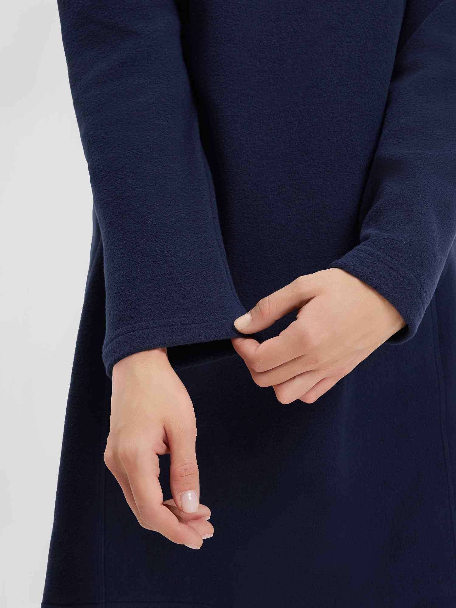 Navy blue hooded fleece dress detail: hands adjusting cuff. Women's outdoor knit style. #color_Navy Blue