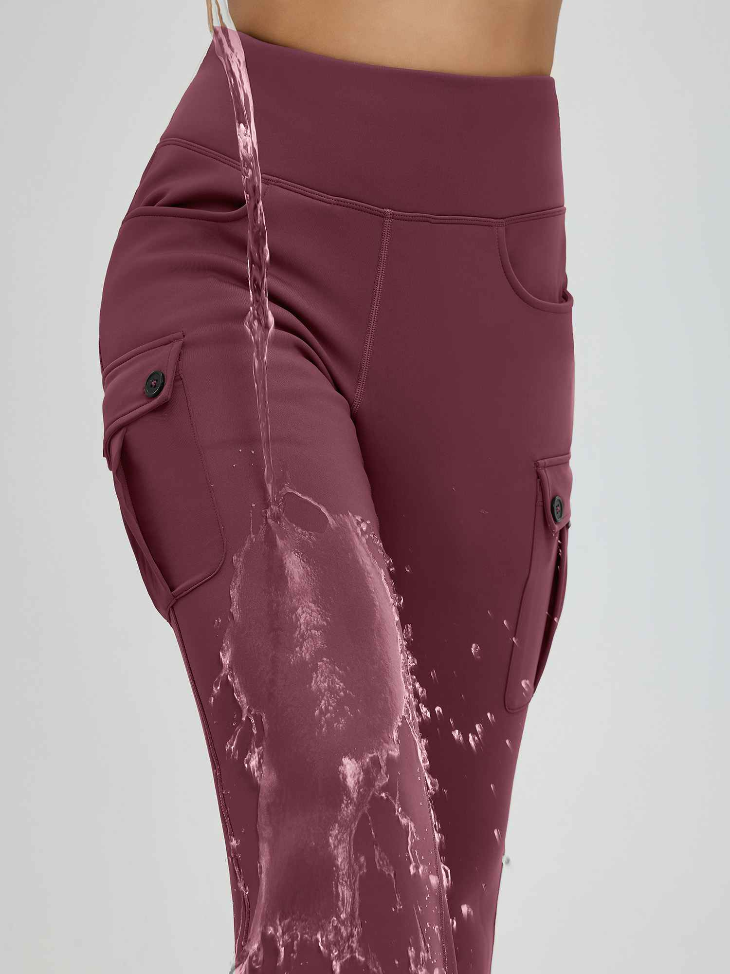 Maroon women's flared workwear pants showing water beading on fabric. Features cargo pockets with buttons. #color_Wine Red