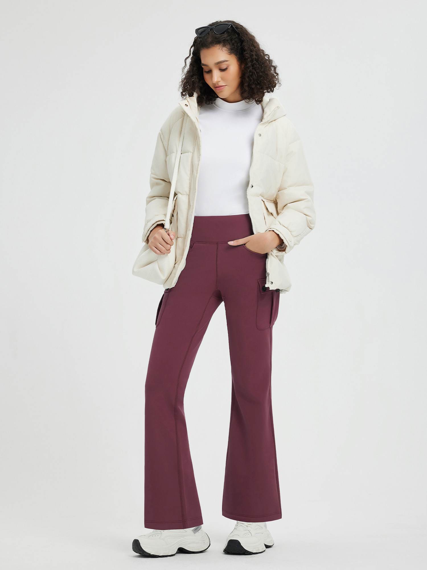 Burgundy fleece flared workwear pants with cargo pockets, white top, cream jacket, white sneakers. #color_Wine Red