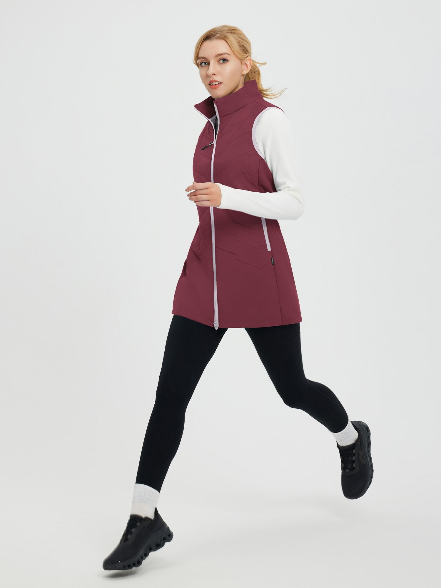 Maroon woven mid-length hiking vest on woman running. White shirt, black leggings, athletic shoes. #color_Wine Red