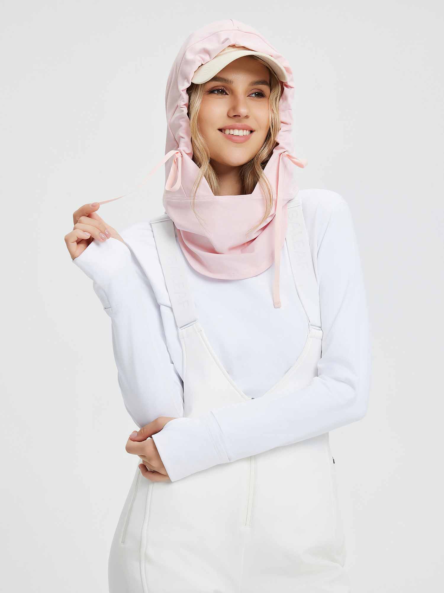 Pink fleece-lined ski hat with adjustable ties and a built-in face mask, worn by a smiling woman. #color_Light Pink