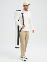 Man in white fleece running half-zip shirt and khaki pants carrying a white golf bag. #color_Star White