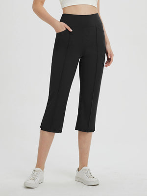 Women's black high-waisted capris with pockets and 21" inseam, paired with white sneakers. #color_Black