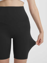 Black women's 8" super high-waisted biker shorts with deep side pockets, showcasing stretch fabric. #color_Black