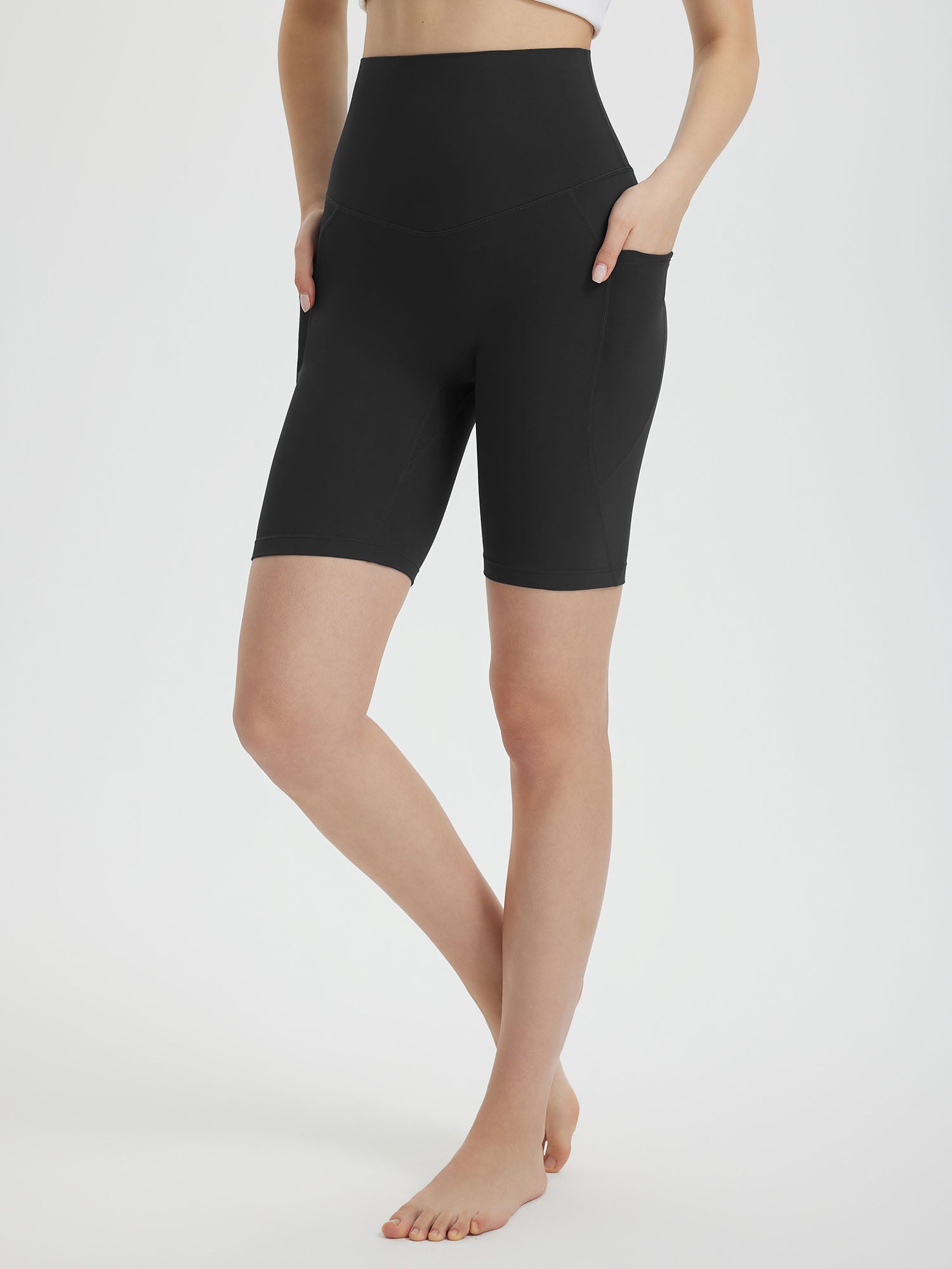 Women's black 8" super high-waisted biker shorts with deep side pockets and a seamless front. #color_Black