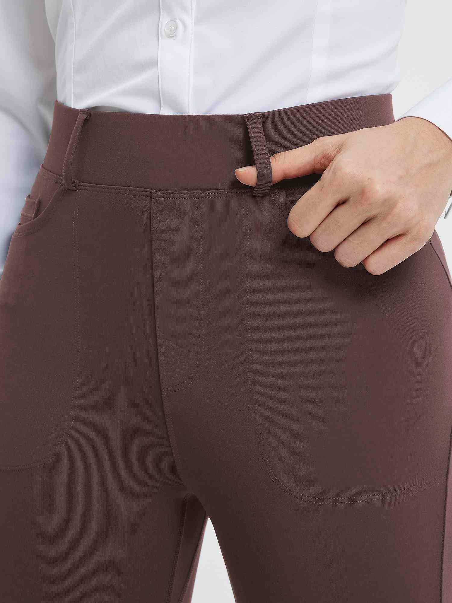 Close-up of dark brown high-waisted yoga business pants, showing a hand adjusting a belt loop. #color_Dark Brown