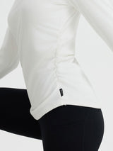 White long-sleeve yoga top with side ruching and BALEAF logo on the hem, paired with black leggings. #Color_Star White