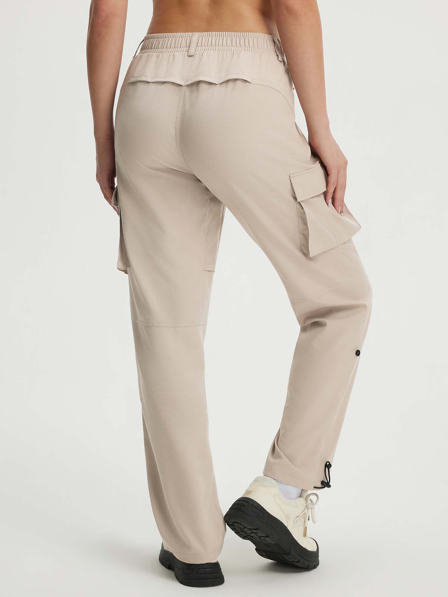 Beige Baleaf ripstop hiking pants with cargo pockets and adjustable ankle drawcords, back view. #color_Khaki