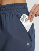 Durable navy ripstop Baleaf hiking pants with secure zip pocket holding smartphone. #color_Navy