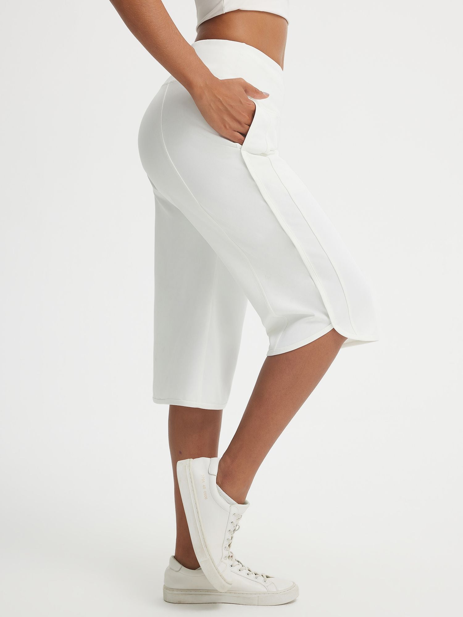 White Baleaf 17-inch high-rise capri pants with side pockets and split hem. #color_White