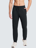 Man wearing black, fleece-lined, reflective jogger pants with a drawstring waist and zippered pocket. #color_Black