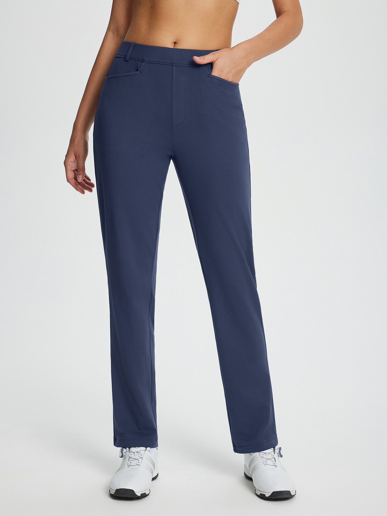 Navy blue fleece-lined straight-leg golf pants with pockets and a white golf shoe. #color_Navy Blue