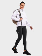 Woman wearing black fleece-lined cycling leggings and a white jacket, carrying a beige backpack. #color_Black