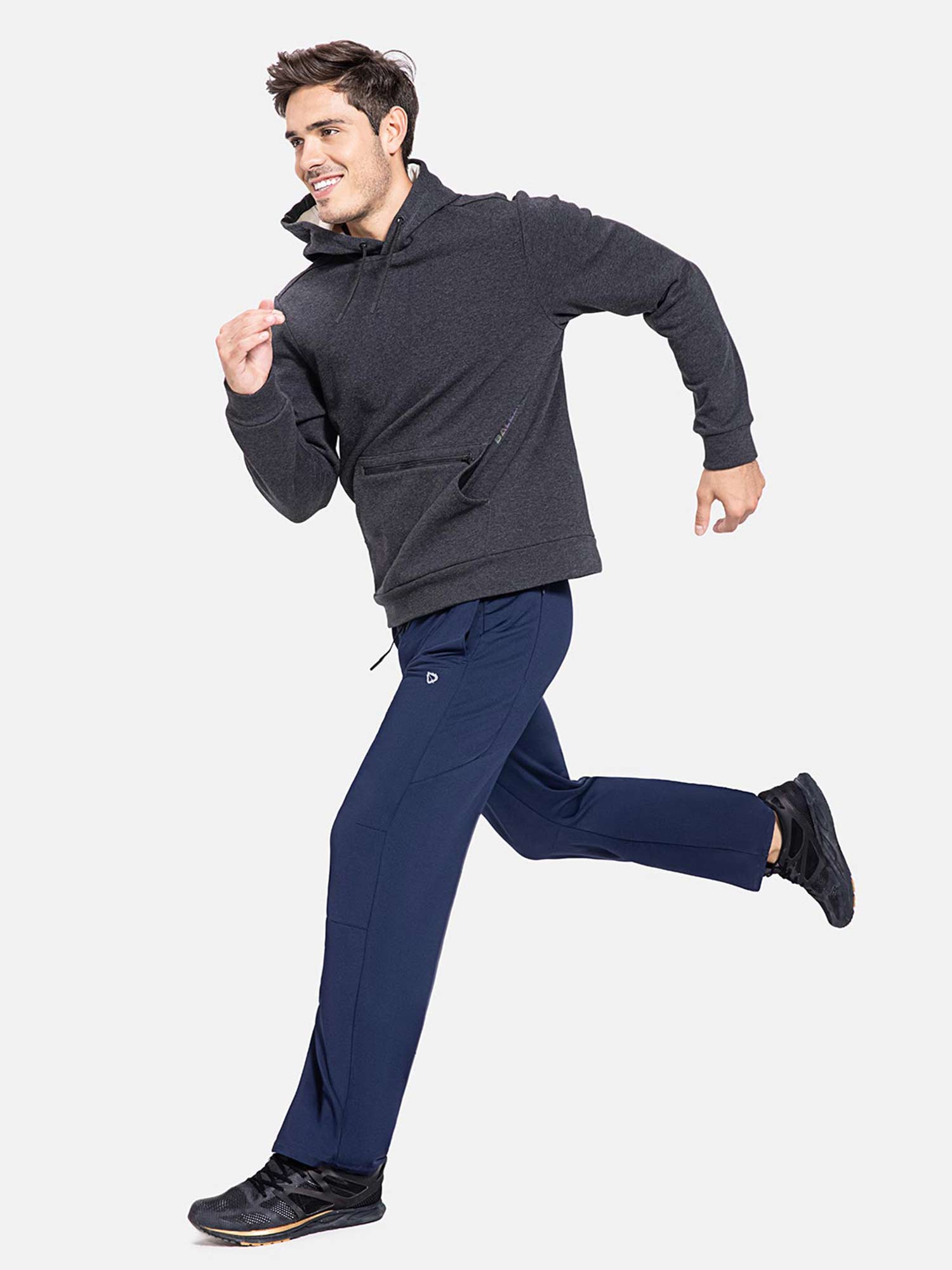 Man running in navy blue fleece-lined water-resistant straight leg pants and charcoal hoodie #color_Navy Blue