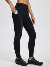 Woman wearing black fleece-padded cycling tights with a phone in the side pocket and cycling shoes. #color_Black