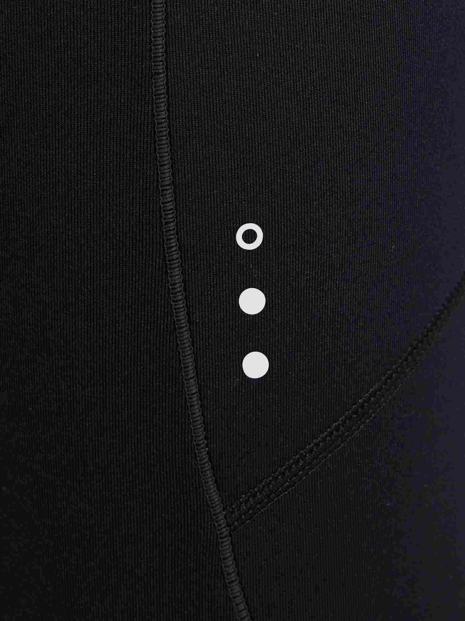 Close-up of black women's fleece-padded cycling tights, showing ribbed texture and reflective dots. #color_Black