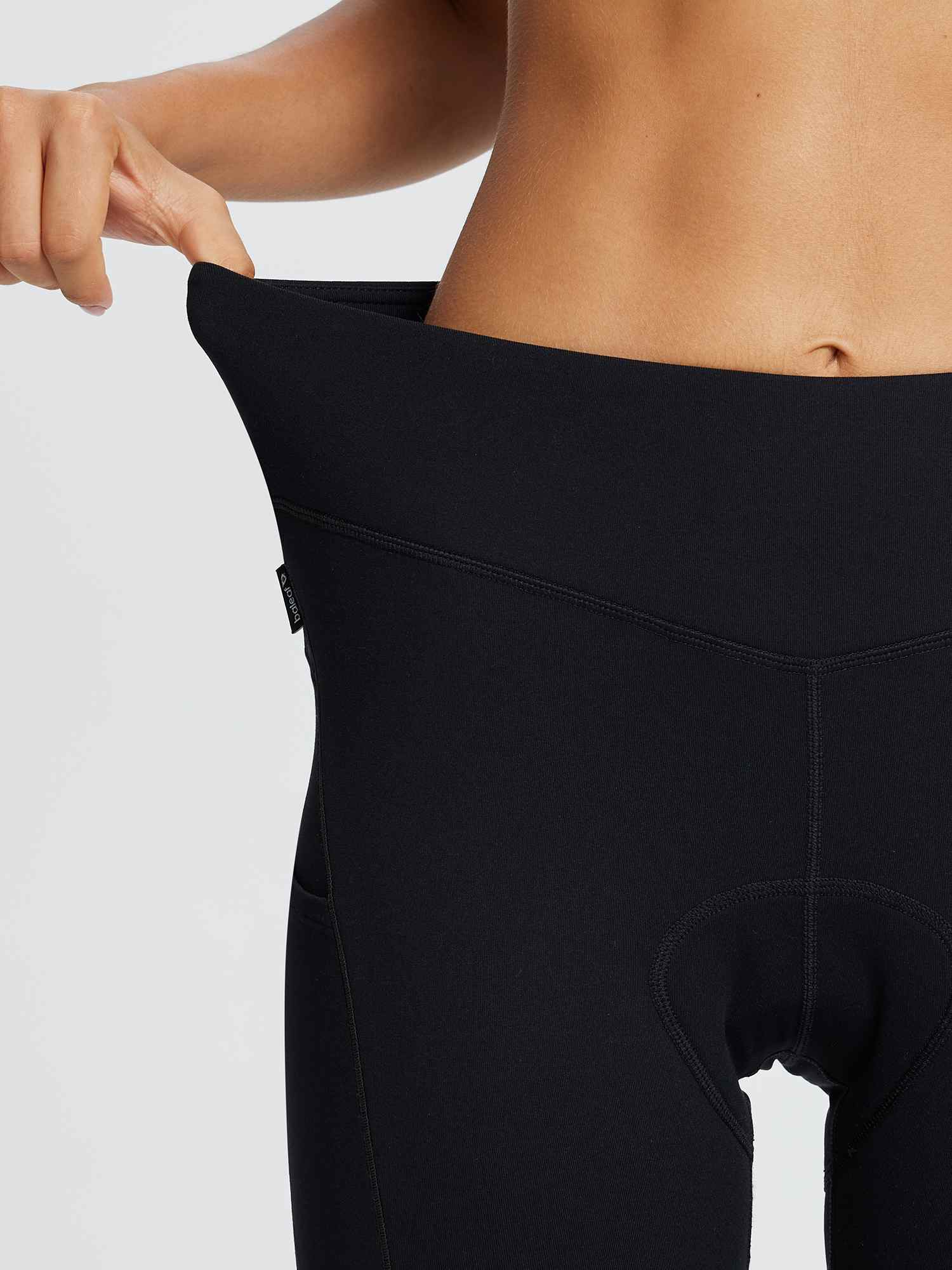 Black fleece-padded cycling tights for women, showcasing elastic waistband and side pocket detail. #color_Black