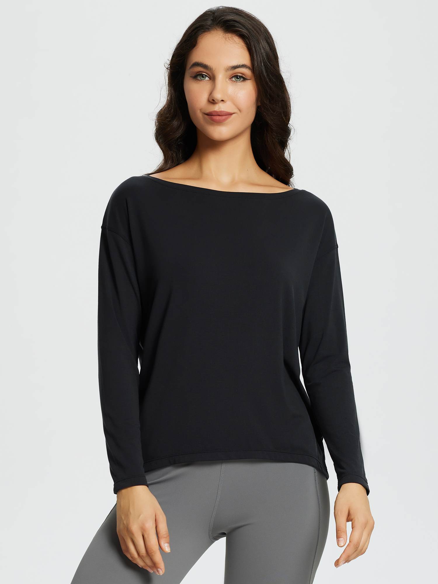 Black long-sleeve workout t-shirt with boat neckline on a woman wearing grey leggings. #color_Black