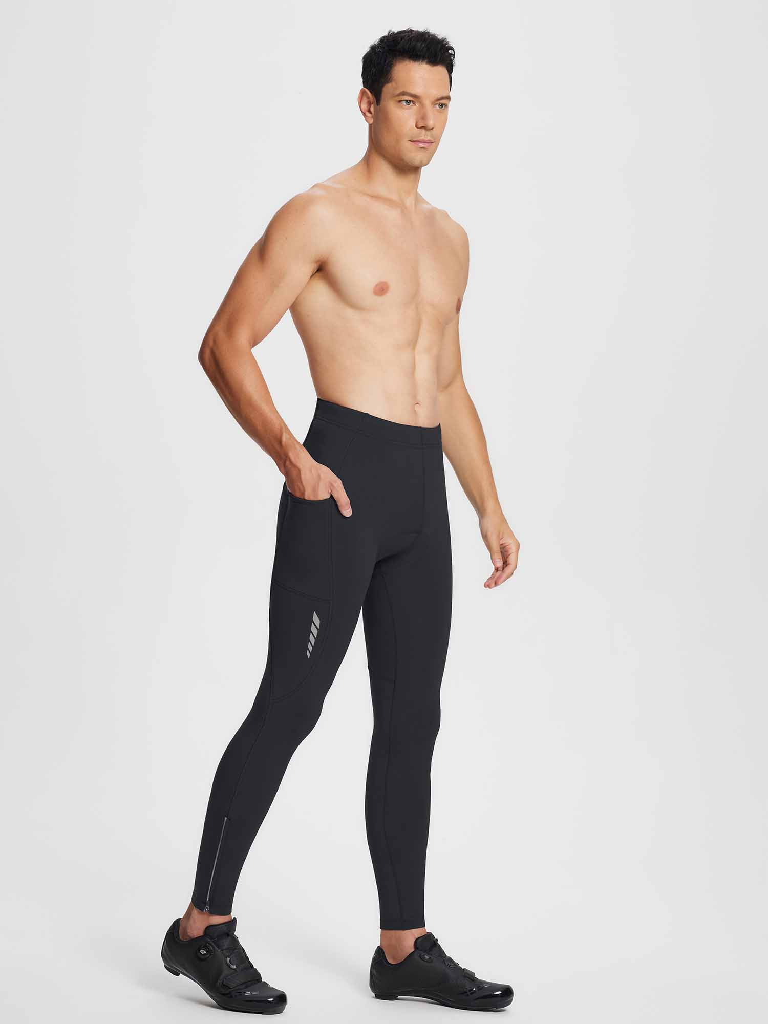 Man wearing black thermal cycling tights with zippered ankles and reflective accents, showcasing side pockets. #color_Black