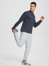 Man in dark gray half-mock knit fleece running top and light gray running pants stretching. #color_Dark Gray