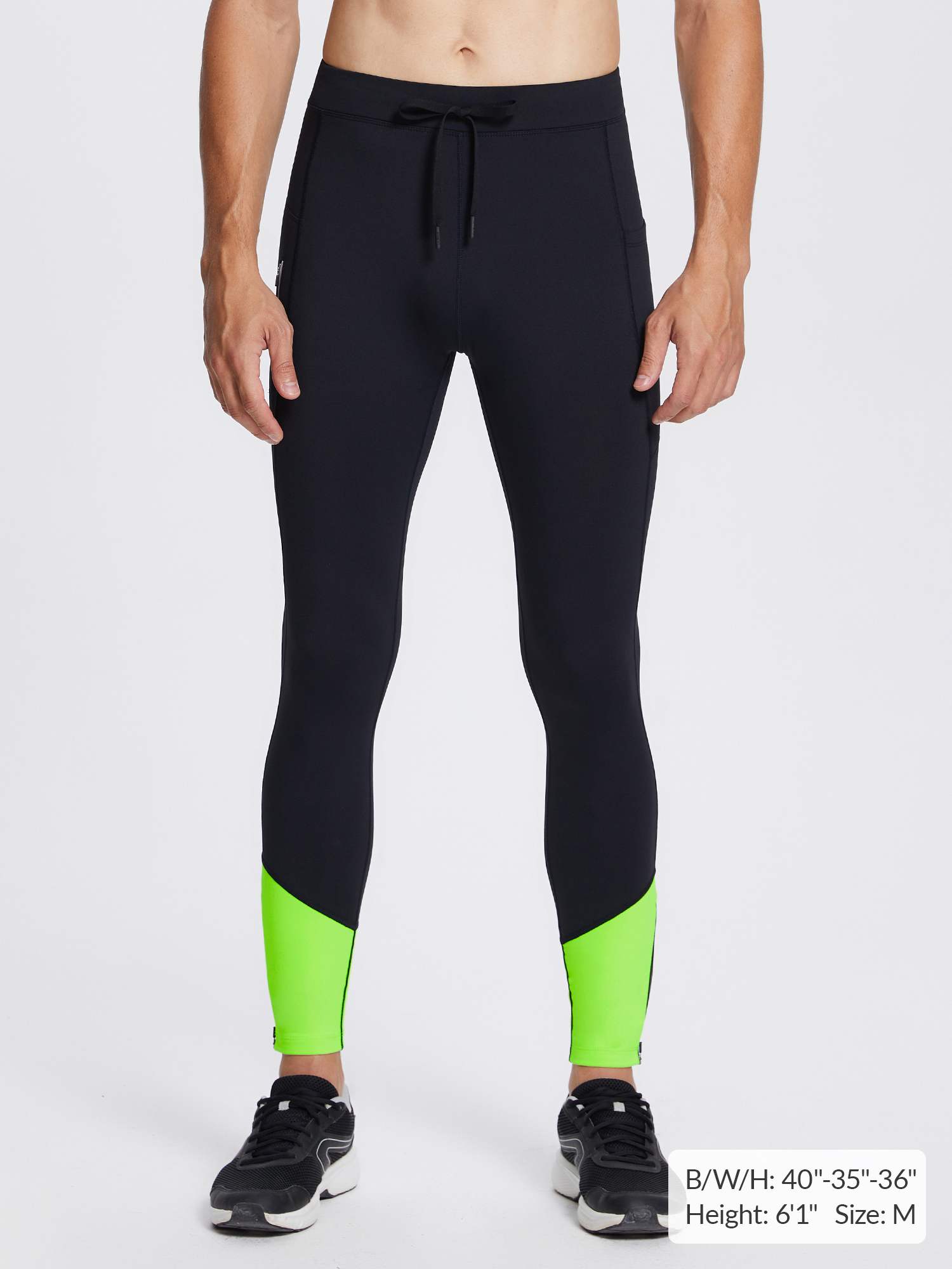 Men's black fleece-lined winter running tights with neon green ankle accents and reflective stripe.