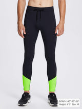 Men's black fleece-lined winter running tights with neon green ankle accents and reflective stripe.