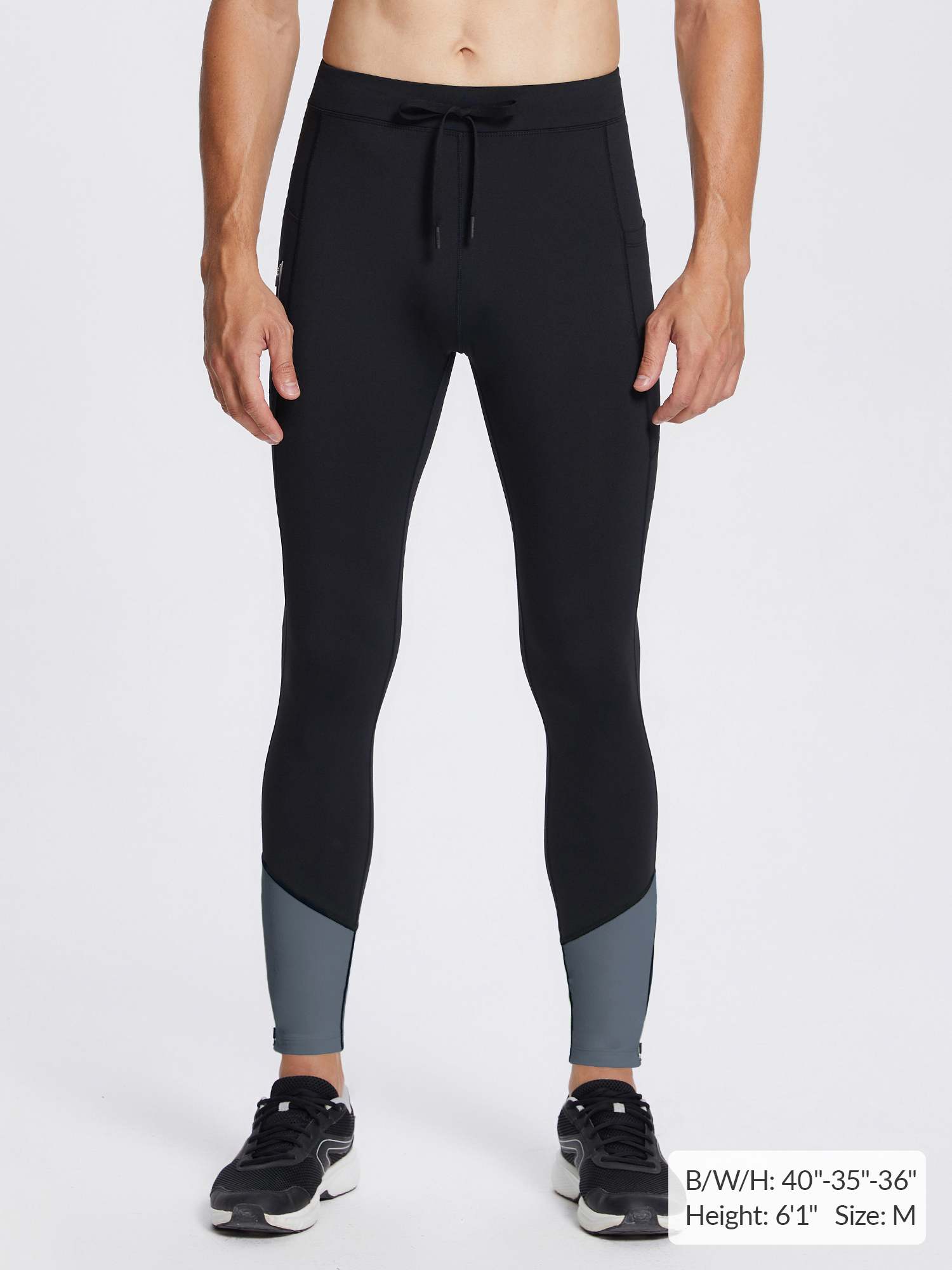 Men's black fleece-lined winter running tights with gray leg panels, featuring drawstring waist and athletic fit.