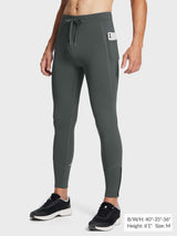 Men's dark gray fleece-lined winter running tights with zippered ankle and phone pocket.