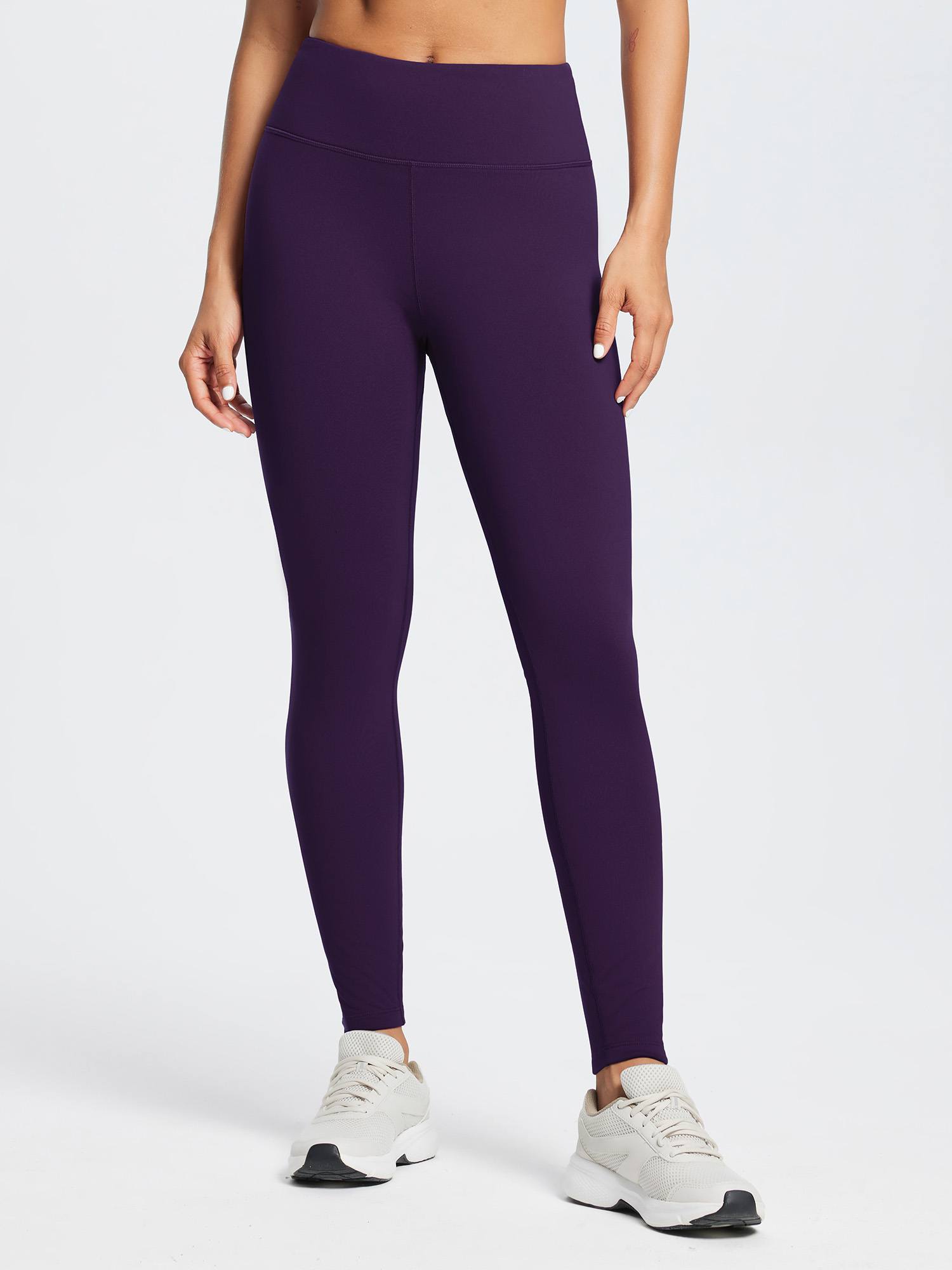 Woman wearing dark purple fleece-lined running leggings with a high waist and white sneakers #color_Dark Purple