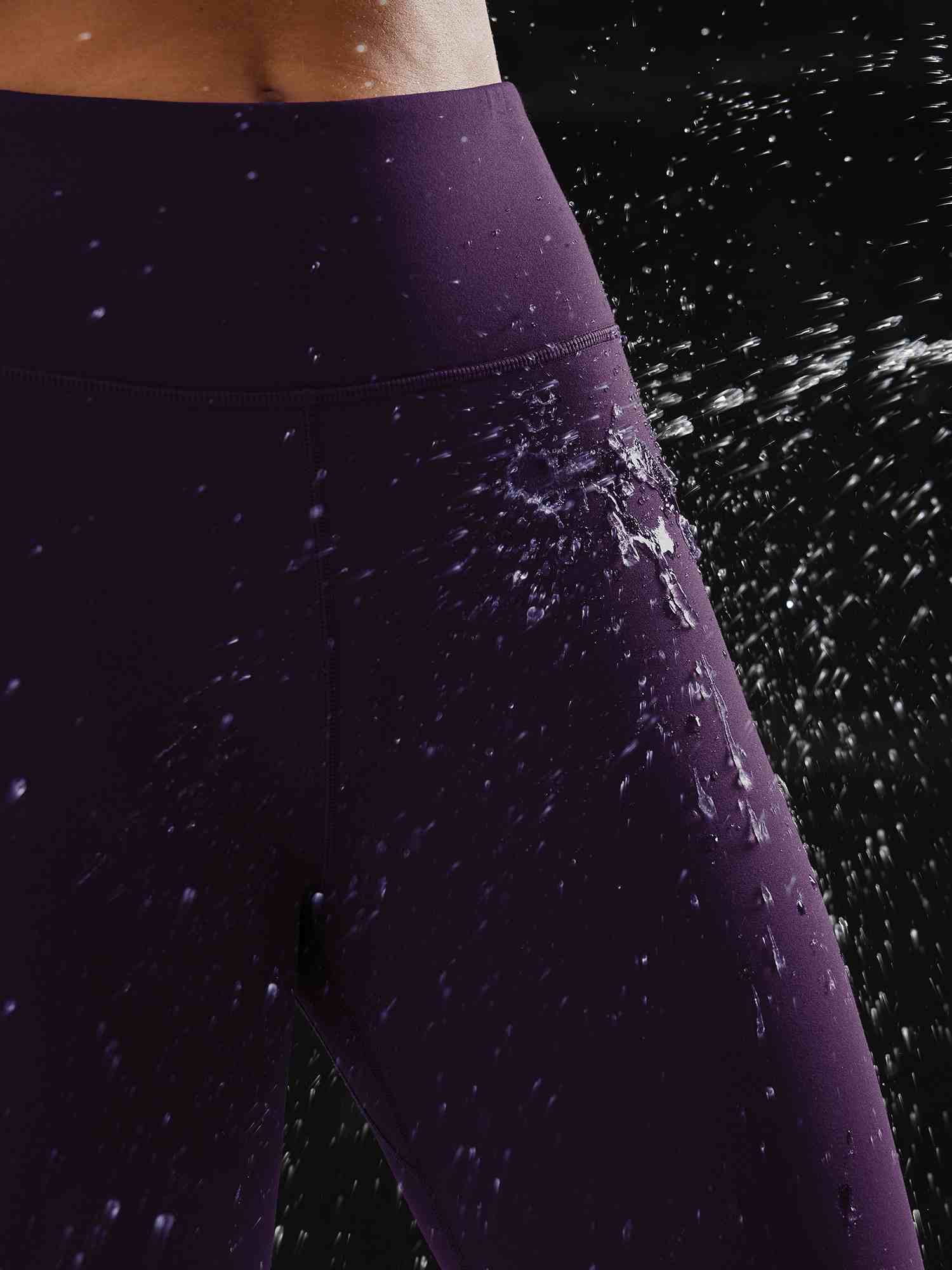 Dark purple fleece-lined running leggings repelling water droplets, showcasing their waterproof feature. #color_Dark Purple