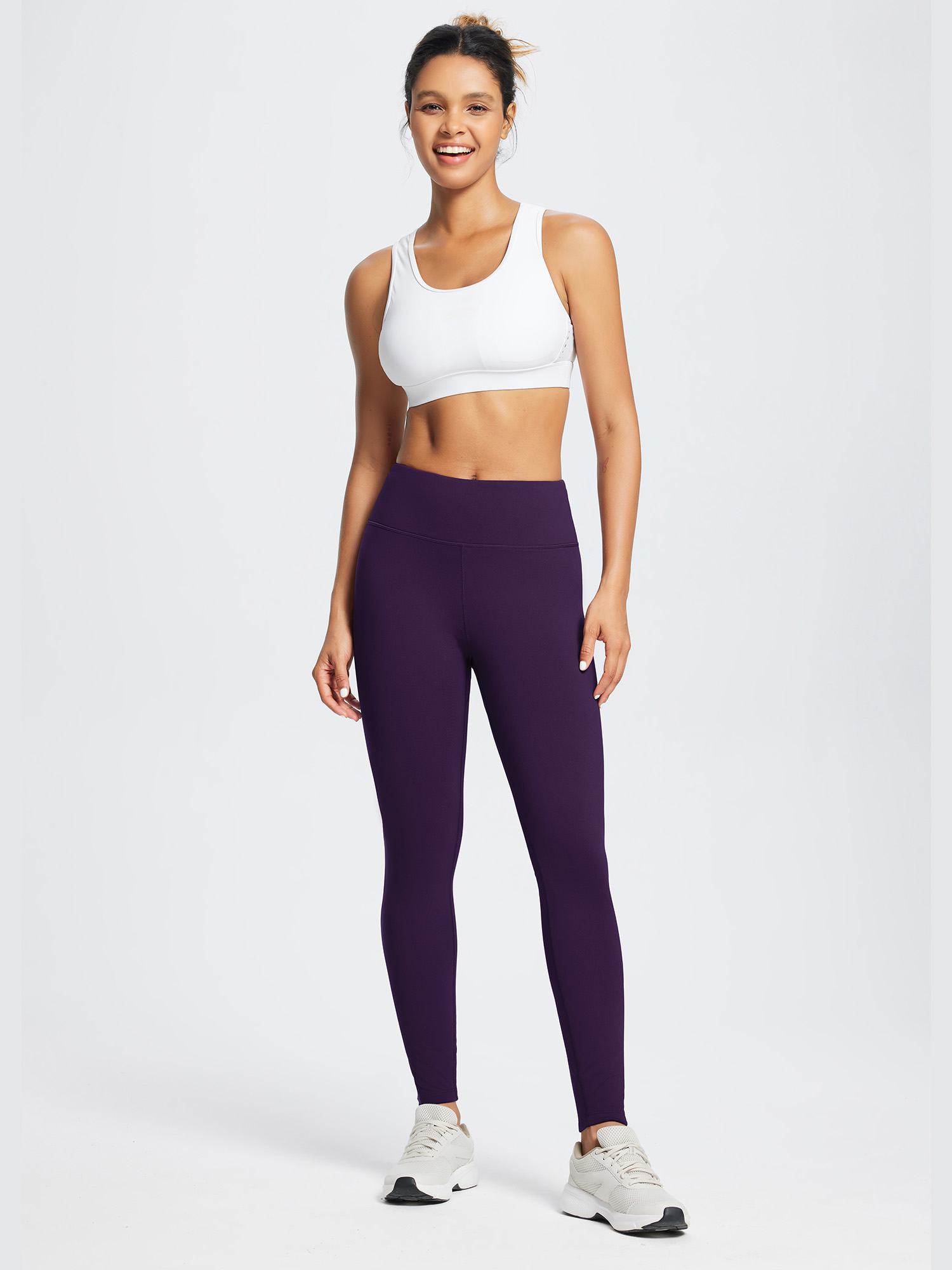Woman wearing dark purple running fleece waterproof skinny leggings and a white sports bra. #color_Dark Purple