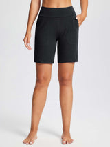 Black knit yoga shorts with a wide waistband and two side pockets, reaching just above the knee. #color_Black
